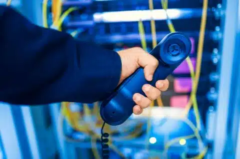Tecnico con cornetta telefonica in sala server